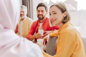 Smiling businessman and businesswoman talking together in office, relaxing. Coffee break concept
