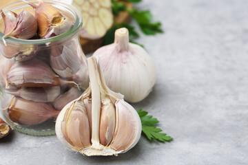 Garlic and parsley on light table, closeup. Space for text