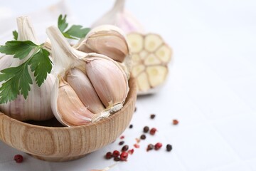Garlic, peppercorns and parsley on white table, closeup. Space for text