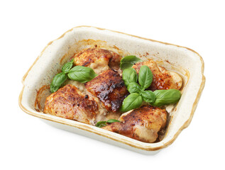 Tasty cooked chicken thighs with basil in baking dish isolated on white