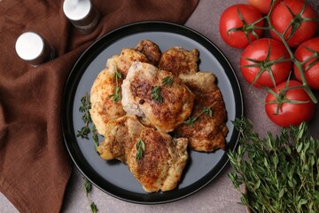 Tasty cooked chicken thighs with thyme and tomatoes on brown table, flat lay