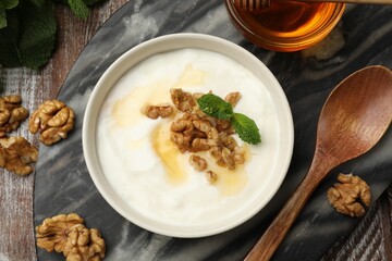 Delicious Greek yogurt with honey, nuts and mint on wooden table, flat lay
