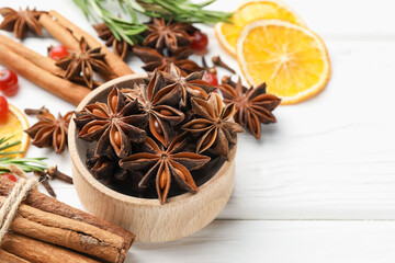 Different spices, dry orange slices and fresh rosemary for mulled wine on white wooden table, closeup. Space for text