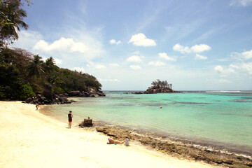Sunny tropical cove with turquoise lagoon and small islet, Mahé, Seychelles – tropical holidays scene