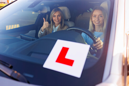 Learner Driver with Instructor Showing Thumbs Up in Vehicle