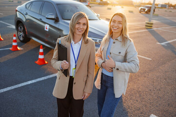 Driving instructor and student giving thumbs up after successful lesson