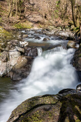 Long exposure of a waterfall on the East Lyn river flowing through the woods at Watersmeet in Exmoor National Park