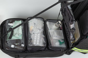 Open  extra large tactical sanitary rescue backpack, inside transparent pockets with tablets and dressing material.