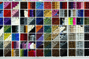 Colorful yarn balls arranged on shelves in a craft and knitting shop