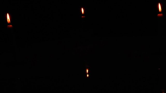 A candle burning in the dark, without electricity, darkness, ritual. Night space glowing softly with flickering light. Calm reflective mood.
