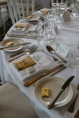 A table with a white tablecloth and a variety of silverware and glassware