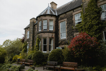 A large stone house with a green ivy growing on it