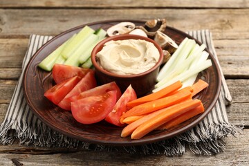 Different fresh vegetables and sauce on wooden table, closeup