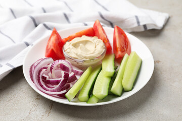 Different fresh vegetables and sauce on light grey table, closeup