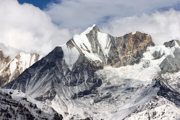 Snow-covered mountains form an impressive view in the Himalayas. Jagged peaks reach towards the sky within the Annapurna Sanctuary near Annapurna Base Camp.