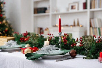 Festive table setting with Christmas decor and burning candles indoors, closeup
