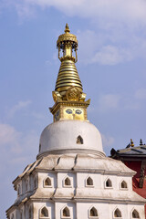 Close-up captures the stupa's golden spire, adorned with iconic Buddha eyes, reaching toward the sky. This landmark stands in Kathmandu, Nepal, representing Buddhist culture.