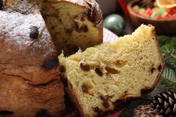 Tasty Christmas panettone cake with powdered sugar and festive decor on table, closeup