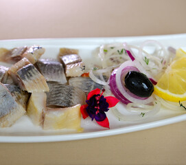Marinated herring fillets with dill, onion rings, peppercorns and lemon isolated on white, top view. High quality photo