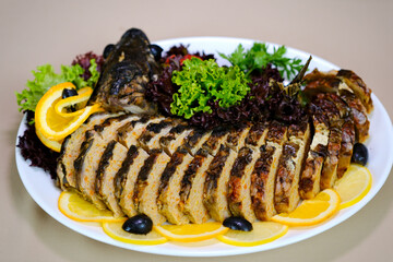 Stuffed fish platter Herb-stuffed trout with tomatoes and green salad . High quality photo