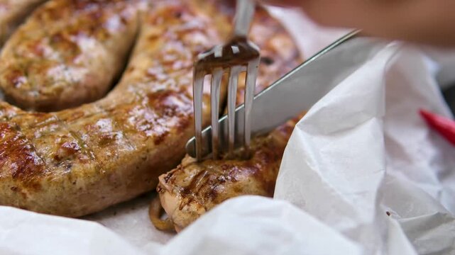 Delicious homemade sausage in the form of a spiral baked on the grill with salt, spices and herbs on a dark concrete background. High quality photo