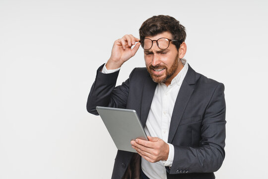 Portrait, confused and business man with tablet in studio isolated on white background. Ceo face, professional boss and angry Caucasian male entrepreneur with touchscreen technology.