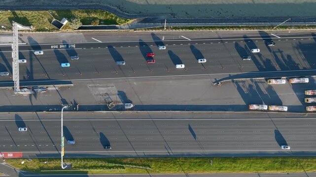 Aerial view of Auckland's Northern Motorway, New Zealand, showing traffic flow and infrastructure. The shot highlights urban transport and coastal proximity.