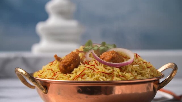 A copper bowl filled with Chicken Biryani