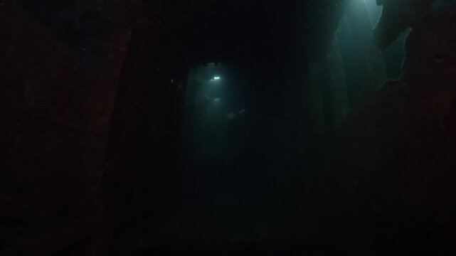 a diver swims through WWII ship wreck underwater in Coron island, Philippines