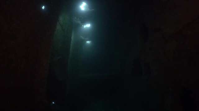 a diver swims through WWII ship wreck underwater in Coron island, Philippines