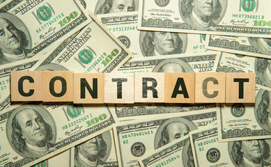 money, wooden cubes and the inscription CONTRACT