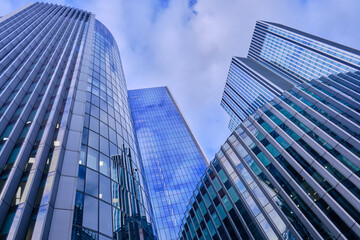 Wide-angle view of skyscrapers in the City of London against a blue sky with light cloud.