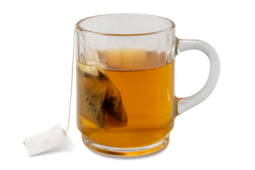 Relaxing digestive herbal tea with chamomile and licorice in a filter bag to be steeped in boiling water in a glass cup isolated