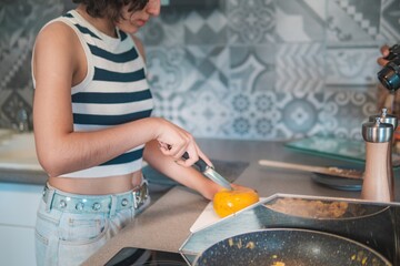 Home cook girl cuts traditional Dutch cheese, helps prepare breakfast