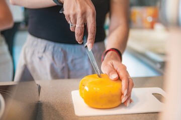 Home cook girl cuts traditional Dutch cheese, helps prepare breakfast