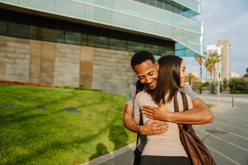 Male and female athletes smiling and hugging