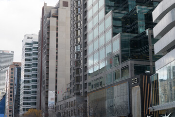Fototapeta premium looking east on Bloor St E, south side, to towers and shops incl Uber at 121 Bloor E, Toronto