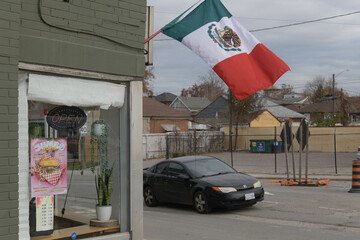 Fototapeta premium exterior of Sofia’s Sweet Cake and Bakery with Mexican flag and vehicle heading SB on Caledonia at Eglinton Av W, Toronto (600 Caledonia Rd)