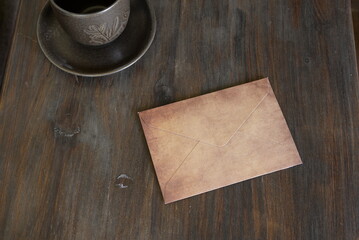 Vintage envelope on rustic wooden table with coffee cup