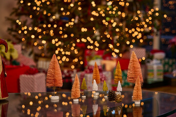 Miniature christmas trees and twinkling lights create a festive holiday atmosphere in the living room