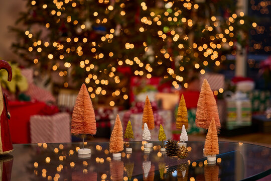 Miniature christmas trees and twinkling lights create a festive holiday atmosphere in the living room