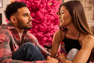 Couple enjoying intimate conversation in front of vibrant pink floral backdrop during romantic date