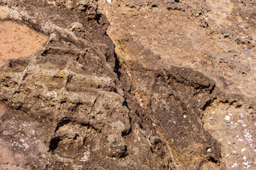 Highly detailed texture of ancient, weathered coastal rock revealing deep crevices and uneven geological formations. Volcanic rock showing deep erosion Excellent background for design.