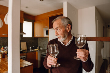 Man holding glasses and looking away