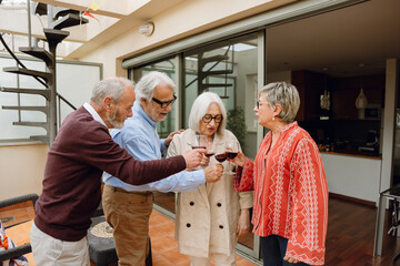 Obraz premium A group of four friends standing and clinking glasses while talking