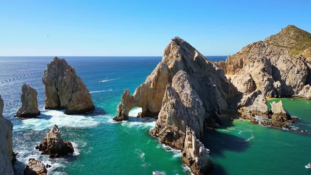 Aerial drone view of the majestic Arch and surrounding cliffs of Cabo San Lucas under clear blue skies