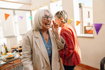 A woman laughs as her female friend walks beside her