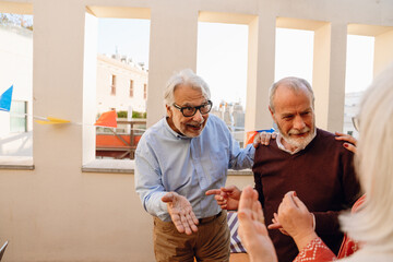 A man speaks in surprise while placing his hand on the shoulder of his male friend who is standing next to him