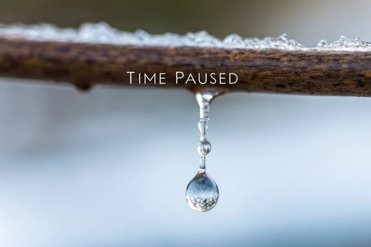 A frozen droplet of water paused in time against blue bokeh