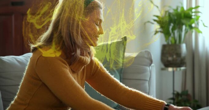 Woman finishing taping holiday gifts, gold effect appearing around hands, placing antler headband